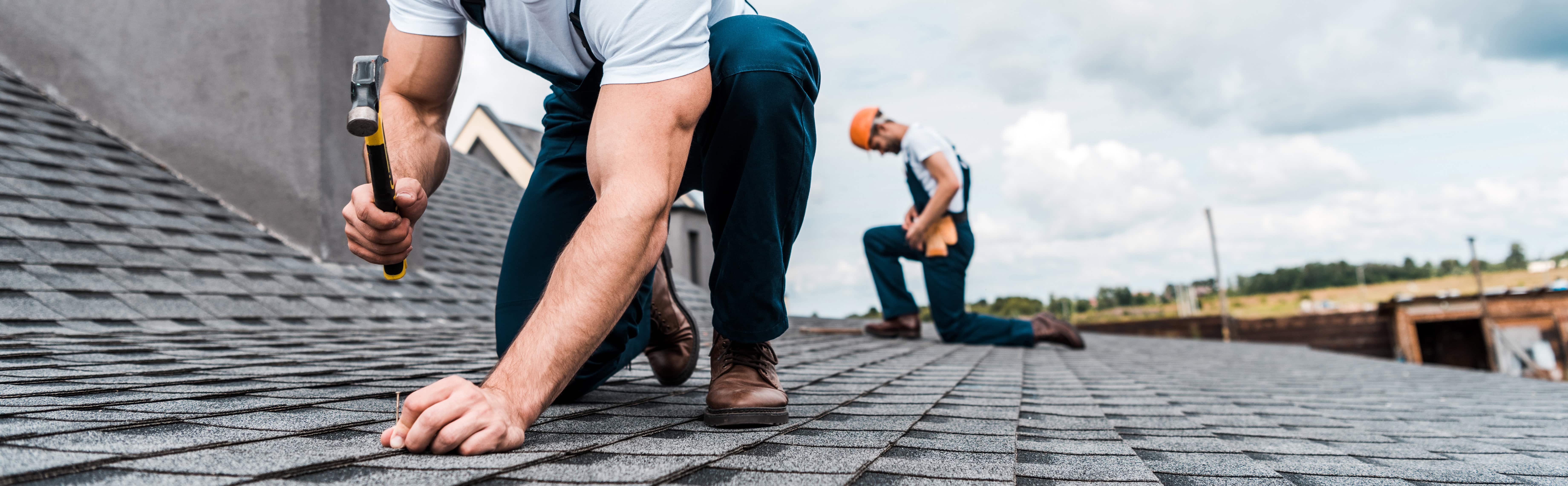 Roof maintenance workers inspecting and repairing a roof
